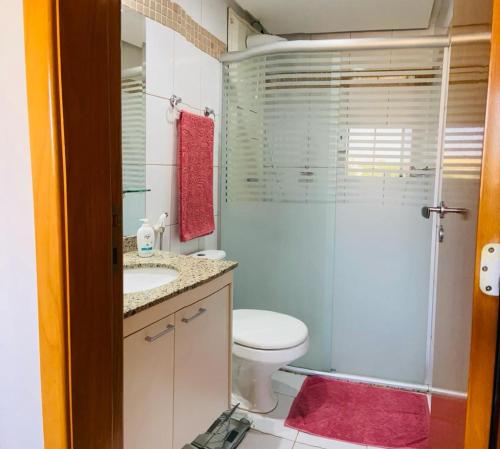 La salle de bains est pourvue de toilettes et d'une douche en verre. dans l'établissement Life Resort - 2 quartos, 2 banheiros, à Brasilia