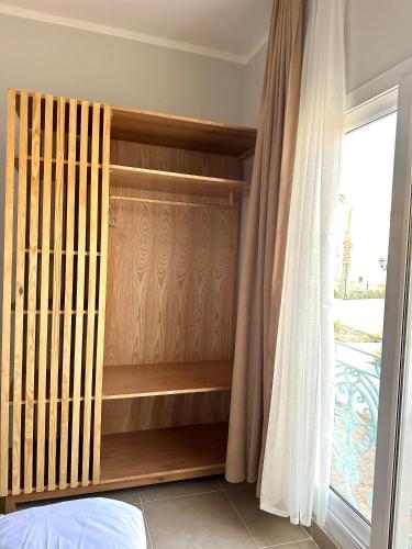a bedroom with a wooden closet with a window at Babushka Boutique Hotel-Dahab in Dahab