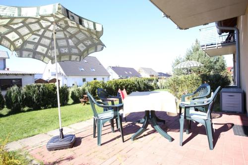 einen Tisch und Stühle unter einem Sonnenschirm auf einer Terrasse in der Unterkunft Ferienhaus Puschmann - FeWo 03 in Zinnowitz