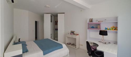 a white bedroom with a bed and a desk at KatlantiK Deluxe Villa in Sal Rei