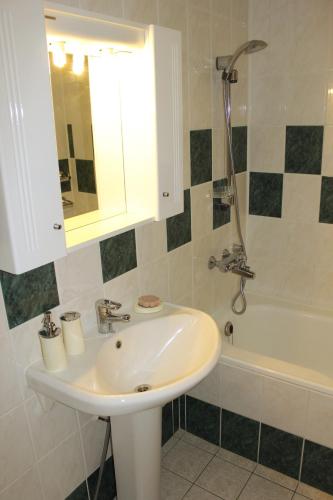 a bathroom with a sink and a bath tub at Avelana Apartment in Pärnu