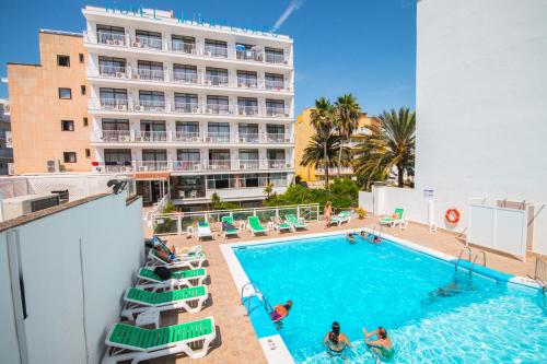 una piscina con un hotel sullo sfondo di Hotel Amic Miraflores a Can Pastilla