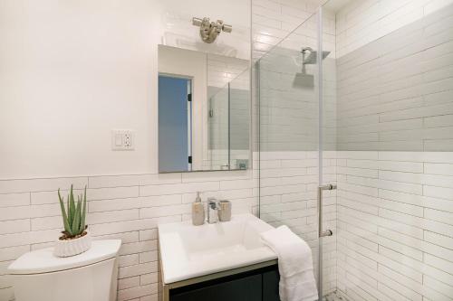 Baño blanco con lavabo y espejo en 1290-13 Newly Renovated 2 Bedrooms in UES, en Nueva York