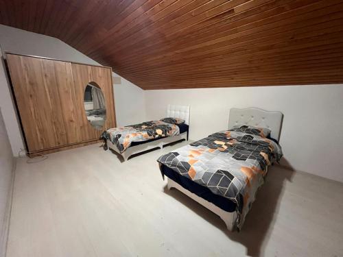 1 dormitorio con 2 camas y techo de madera en Villa taş en Alanya