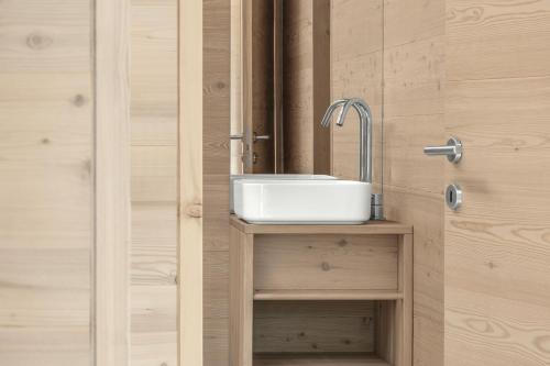 a bathroom with a sink next to a door at Tabia' Stelo Fiorito in Santo Stefano di Cadore