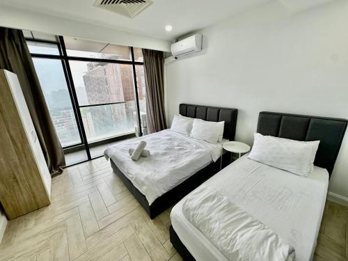 Habitación de hotel con 2 camas y ventana en Empire City Hotel Petaling Jaya en Petaling Jaya