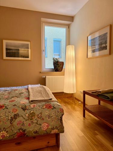 a bedroom with a bed and a window and a table at Traum-Stadt-Wohnung in Augsburg