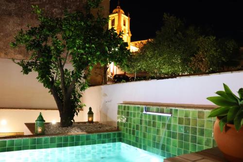 a pool with a tree and a building in the background at Casa da Sé in Silves