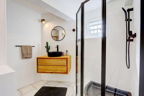 ein Bad mit einer Dusche und einem Waschbecken in der Unterkunft Bec Rose - Clim - Wi-fi - Jardin in Saint-Leu