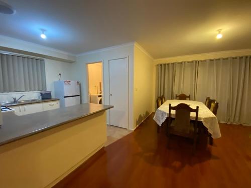 una cucina con un tavolo e un piano di lavoro di 5 Beds-Whole House-Carrum Beach- Patterson Lake-Fully Furnished a Carrum