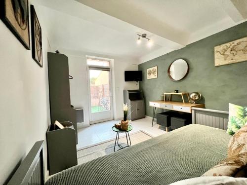 - un salon avec un lit et un bureau dans l'établissement Petit Studio Charmant, à Toulon