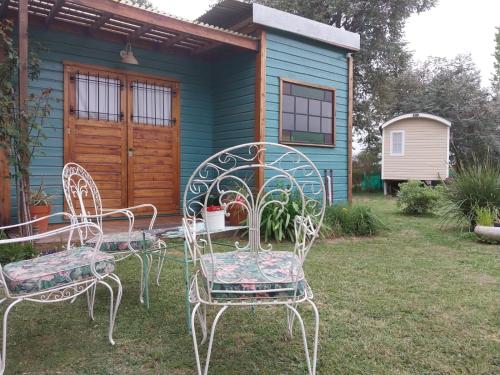 a group of chairs and a table in front of a house at Las Nativas de Areco in San Antonio de Areco