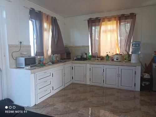 a kitchen with white cabinets and a microwave at villas andrez in Savinia