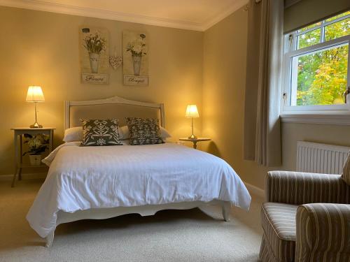 a bedroom with a white bed and a window at Westwood Cottage in Aboyne