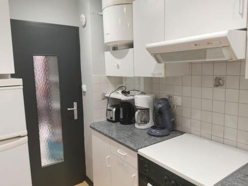 une cuisine avec des armoires blanches et un comptoir dans l'établissement Appartement meublés à Villeurbanne Lyon, à Villeurbanne