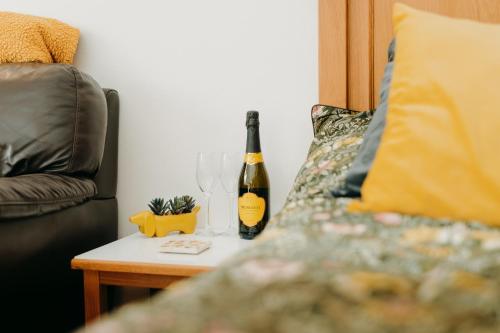 una botella de vino en una mesa junto a un sofá en Luxury Private Suite-Parking, Courtyard & Wi-Fi, en Caldicot