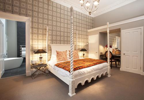 a bedroom with a canopy bed and a bath tub at The Rutland Hotel & Apartments in Edinburgh