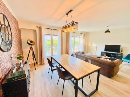 una sala de estar con una mesa y un sofá en La Pause Confortable, en Perpiñán