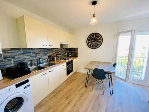 une cuisine avec un évier et une machine à laver dans l'établissement La Pause Confortable, à Perpignan