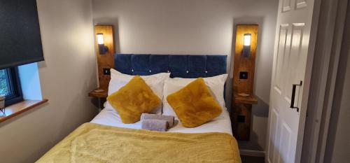 a bedroom with a bed with two yellow pillows at Country Style, 2 bedroom house, Parking and superb location in Norwich