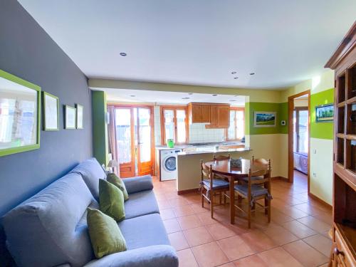 a living room with a blue couch and a table at Apartaments La Bonaigua in Valencia de Aneu