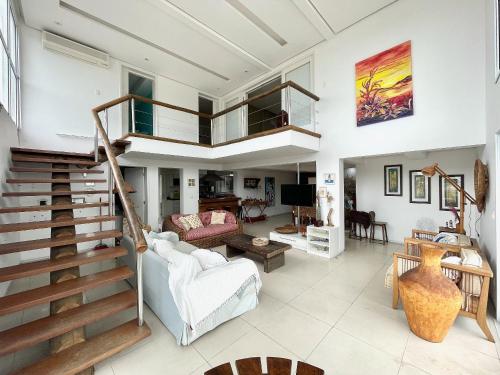 a living room with a staircase and a living room at DUPLEX MONTECARLO in Ubatuba