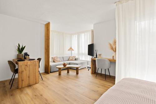 ein weißes Zimmer mit einem weißen Sofa und einem Tisch in der Unterkunft Gemütliche Wohnung mit Charme - Smart TV in Gießen