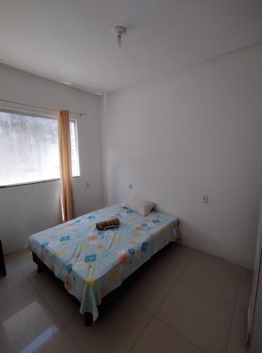 een slaapkamer met een bed in een kamer met een raam bij Apto 3/4 in Serrinha