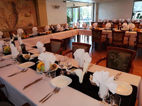 a dining room with tables with white tablecloths and napkins at Terra Europe Brontes Hotel in Targovishte