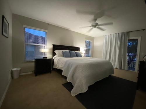1 dormitorio con 1 cama y ventilador de techo en Beautiful 4 Bedroom Vacation Home at Regal Palms Resort, close to Disney World, en Davenport