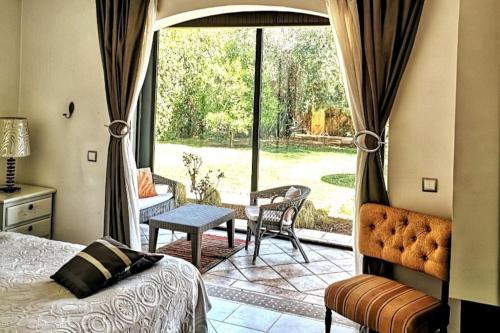 a bedroom with a bed and a view of a patio at Lovely Villa Amelkis One Marrakech in Marrakech