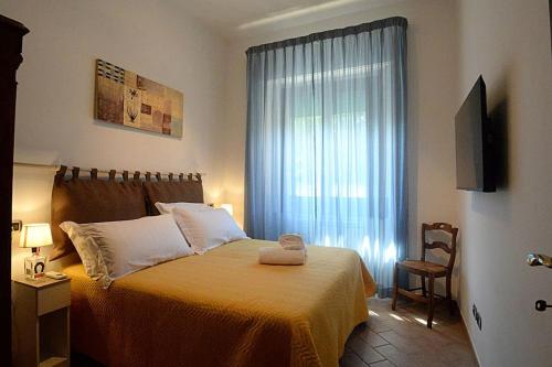 een slaapkamer met een bed met een raam en een stoel bij La Casa di Ambra in Chianciano Terme