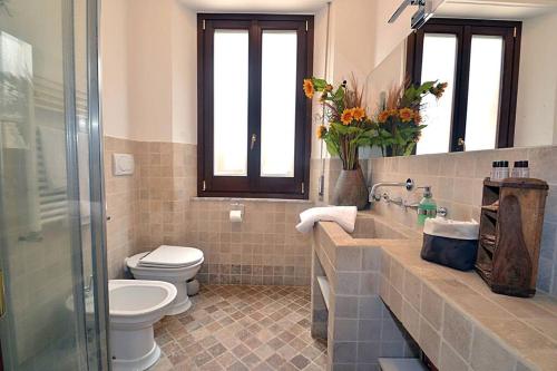 een badkamer met een toilet en een glazen douche bij La Casa di Ambra in Chianciano Terme