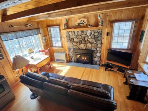 - un salon avec un canapé et une cheminée dans l'établissement Private Cabin on 1.7 acres w/ Fireplace White Mtns, à Intervale