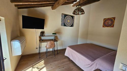 sypialnia z łóżkiem, biurkiem i telewizorem w obiekcie La Casa del Corso w mieście Arcidosso