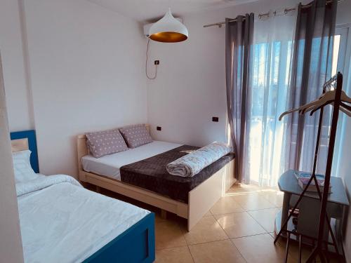 een kleine slaapkamer met 2 bedden en een raam bij Dardana&Gerjon apartament in Bathoria