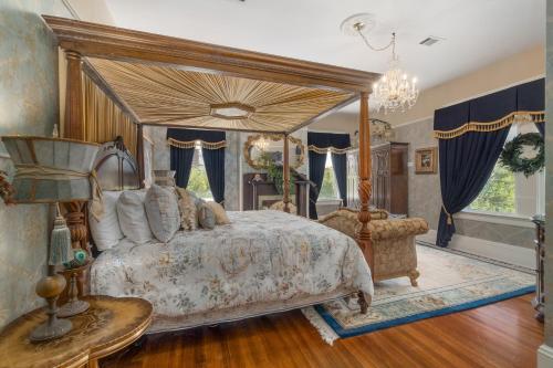 sypialnia z łóżkiem z baldachimem i stołem w obiekcie Ross Mansion Bed & Breakfast w mieście Hattiesburg