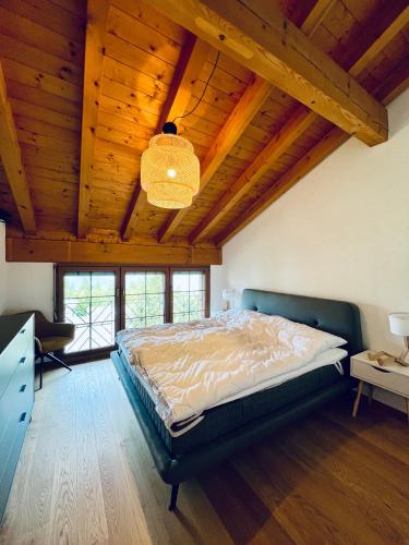 a bedroom with a bed and a wooden ceiling at Alpenresidenz - CharmingStay in Flumserberg