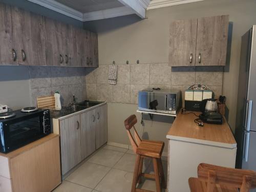 cocina con armarios de madera y encimera en Tenlet guesthouse en Pretoria