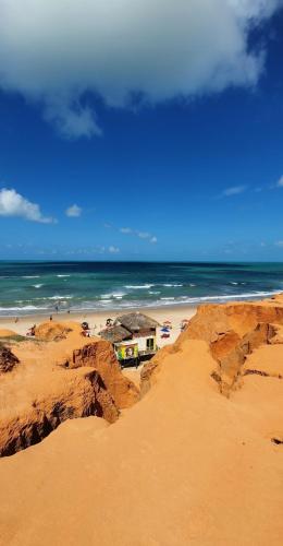 a beach with a house on the sand and the ocean at NOVO Chalé Pôr do Sol Canoa Quebrada in Aracati