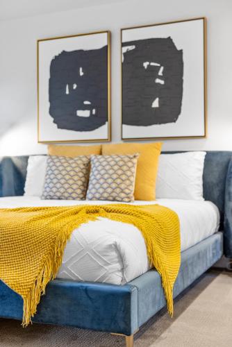a bed with a yellow blanket on a blue couch at Trendy 3BR in Sedona: Hot Tub/Fire-pit /Central Location in Sedona