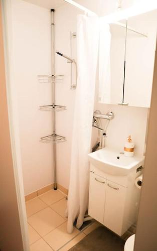 a white bathroom with a shower and a sink at Mökki in Kalkkinen in Lahti