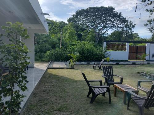 a group of chairs and tables in a yard at Hotel Magic Capurganá in Capurganá