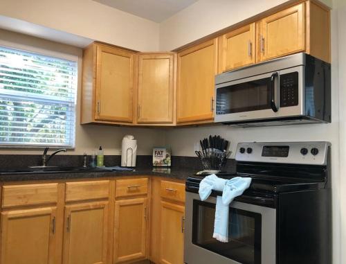 a kitchen with wooden cabinets and a stove top oven at WALK TO BEACH: 3BR home with spacious backyard in Jacksonville Beach