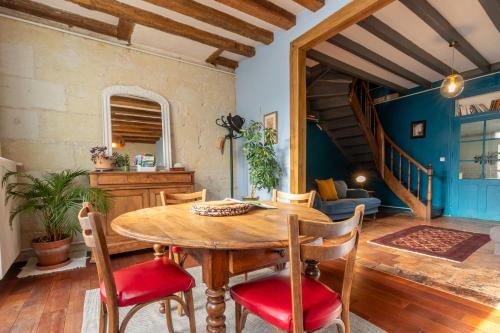 a dining room with a wooden table and chairs at Chez Miriam - Maison de caractère - Ville avec jardin in Montrichard
