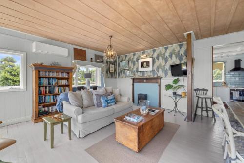 a living room with a couch and a table at Driftwood Paradise in Purerua