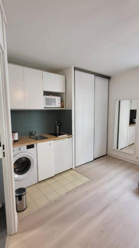 une cuisine avec un lave-linge et un micro-ondes dans l'établissement Studio confortable et charmant, à Paris