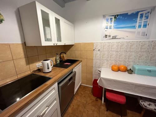 a kitchen with white cabinets and a table with oranges on it at A&R Brzozowa 5 in Rowy