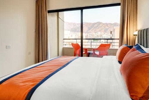 a bedroom with a bed and a large window with a view at THE LOFT HOTEL By BRATUS in Aqaba