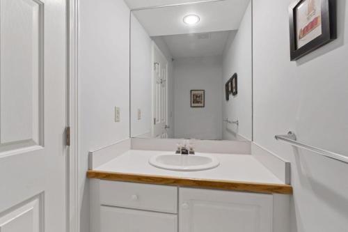 a white bathroom with a sink and a mirror at New host! Exceptional Sunday River Ski In Ski Out Condo in Newry
